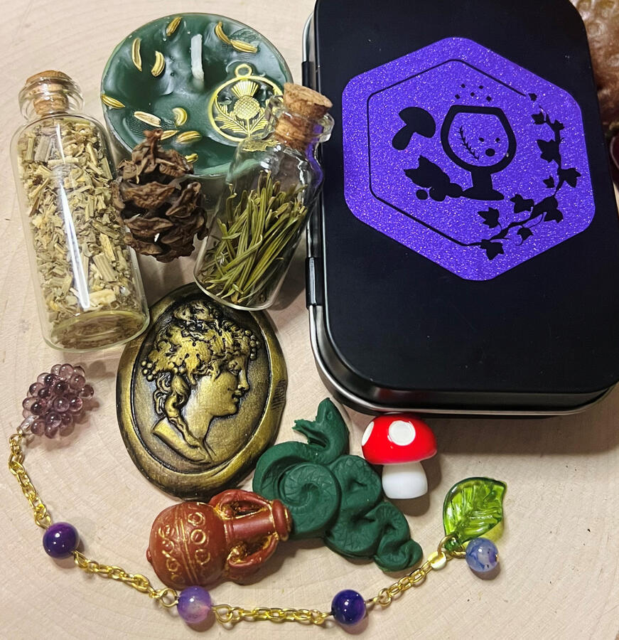 Travel altar to the god Dionysos, including: Dionysos intaglio, snake altar tile, amphora altar tile, miniature Amanita muscaria, bottle of pine needles, bottle of wormwood, small pine cone, prayer beads with purple dragon's vein agate beads finished at on